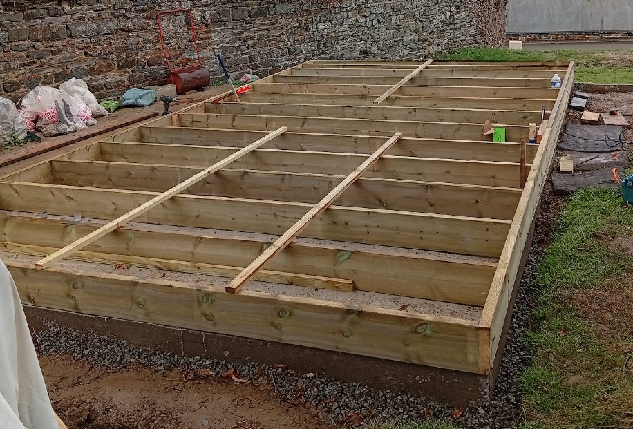 ossature en bois du plancher posée sur la dalle du gîte Le Relais de Chaumeré